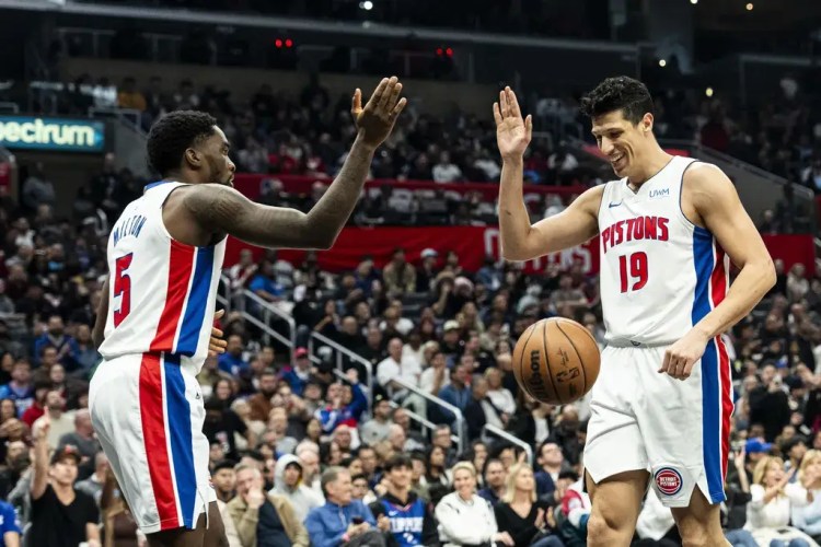 Detroit Pistons players high-five on the court