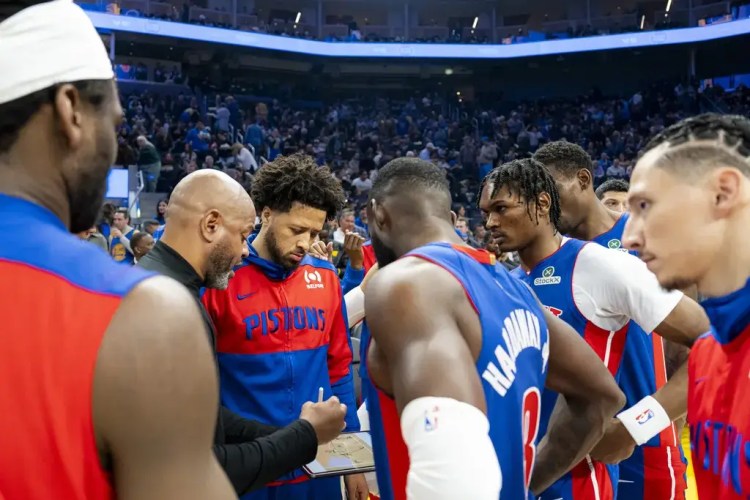 Detroit Pistons teammates huddle as coach J.B. Bickerstaff calls a play