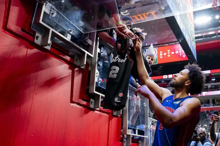 Detroit Pistons' guard, Cade Cunningham, signs a fans jersey