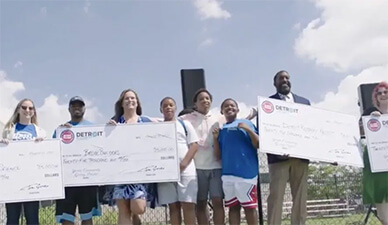 Representatives of several organizations hold oversize novelty checks that represent donations