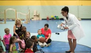 An educator speaks to a group of small children