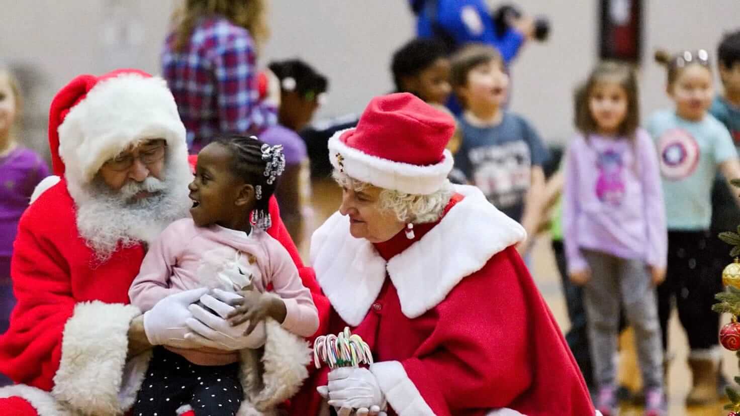 Santa and Mrs. Claus greet some children