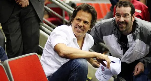 Tom Gores poses with a fan at a Pistons game