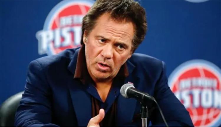 Tom Gores replies to a reporter at a press conference