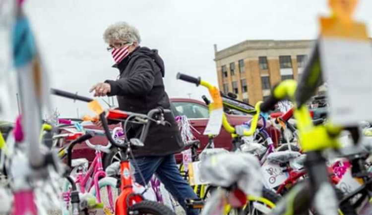 A woman walks between rows of bicycles donated to be given away to children