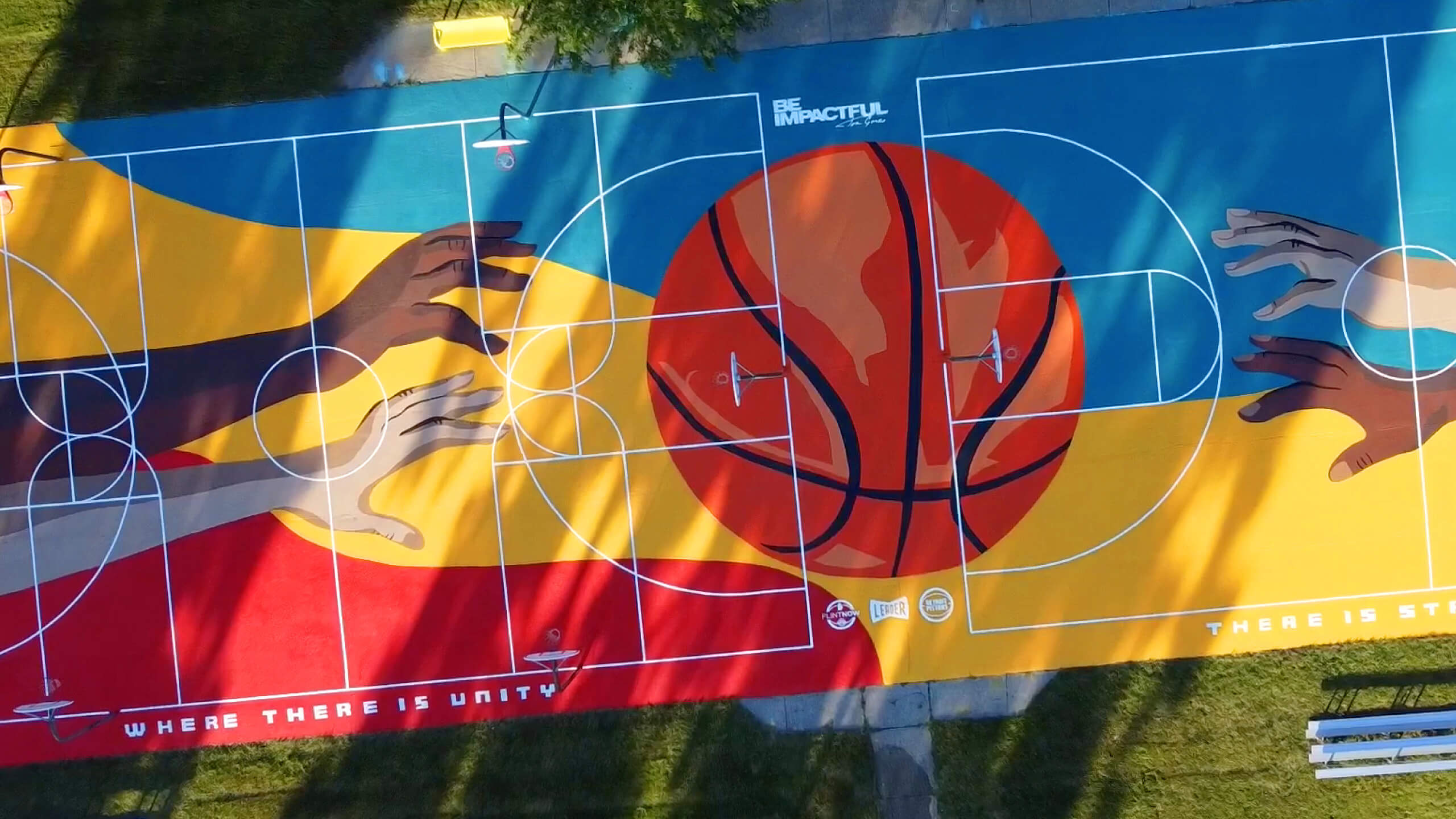 Overhead view of a colorfully painted basketball court with the logo, "Be Impactful"